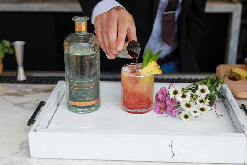 Remedio de Hierbas pineapple sotol cocktail with a sunrise gradient