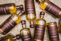 Flat lay of numbered Los Magos WhistlePig Edition #1 bottles on marble, showing the limited edition bottle numbering